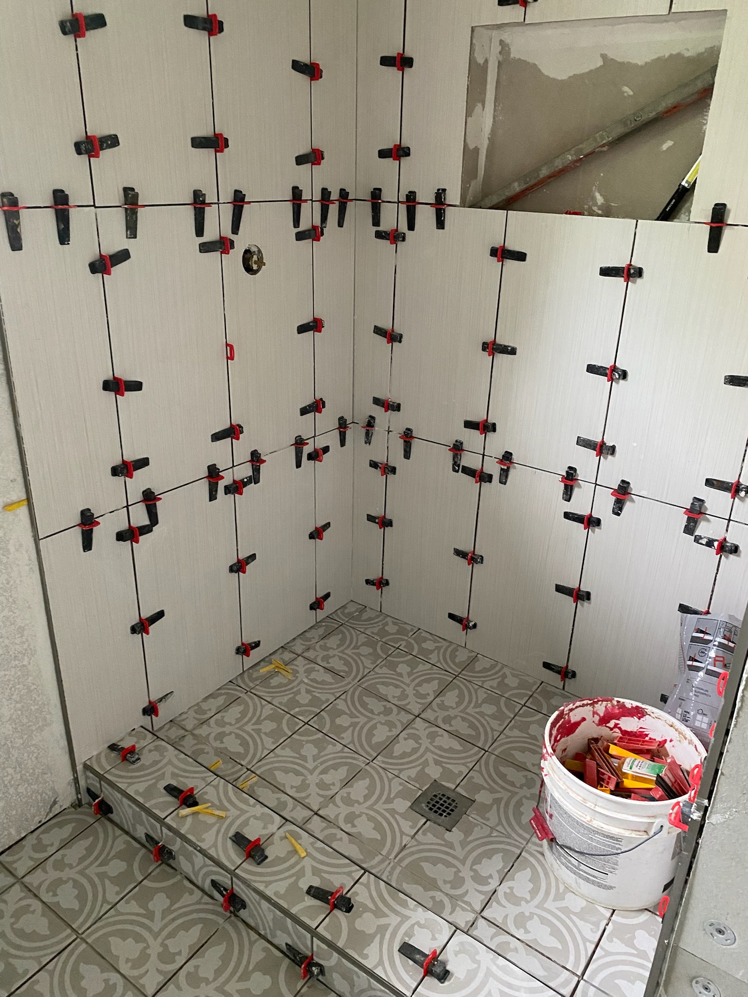 Tile leveling clip system installation on custom shower walls and floor